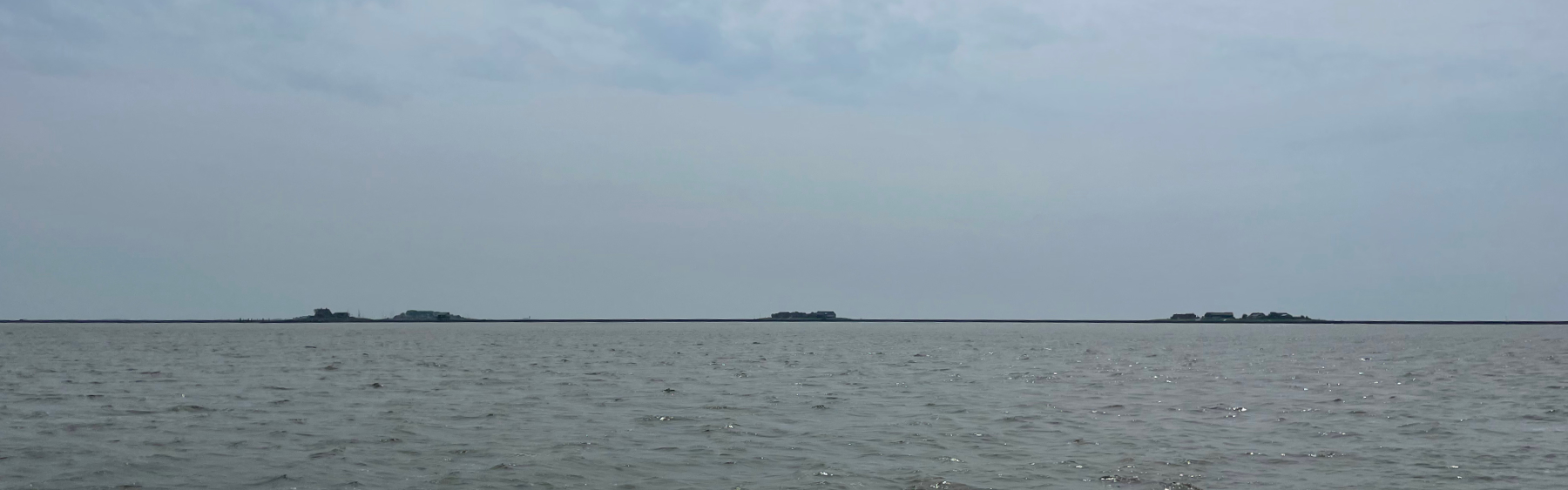 Uitzicht vanaf het water naar de Halling, er steken net enkele terpen boven het water uit met de bebouwing